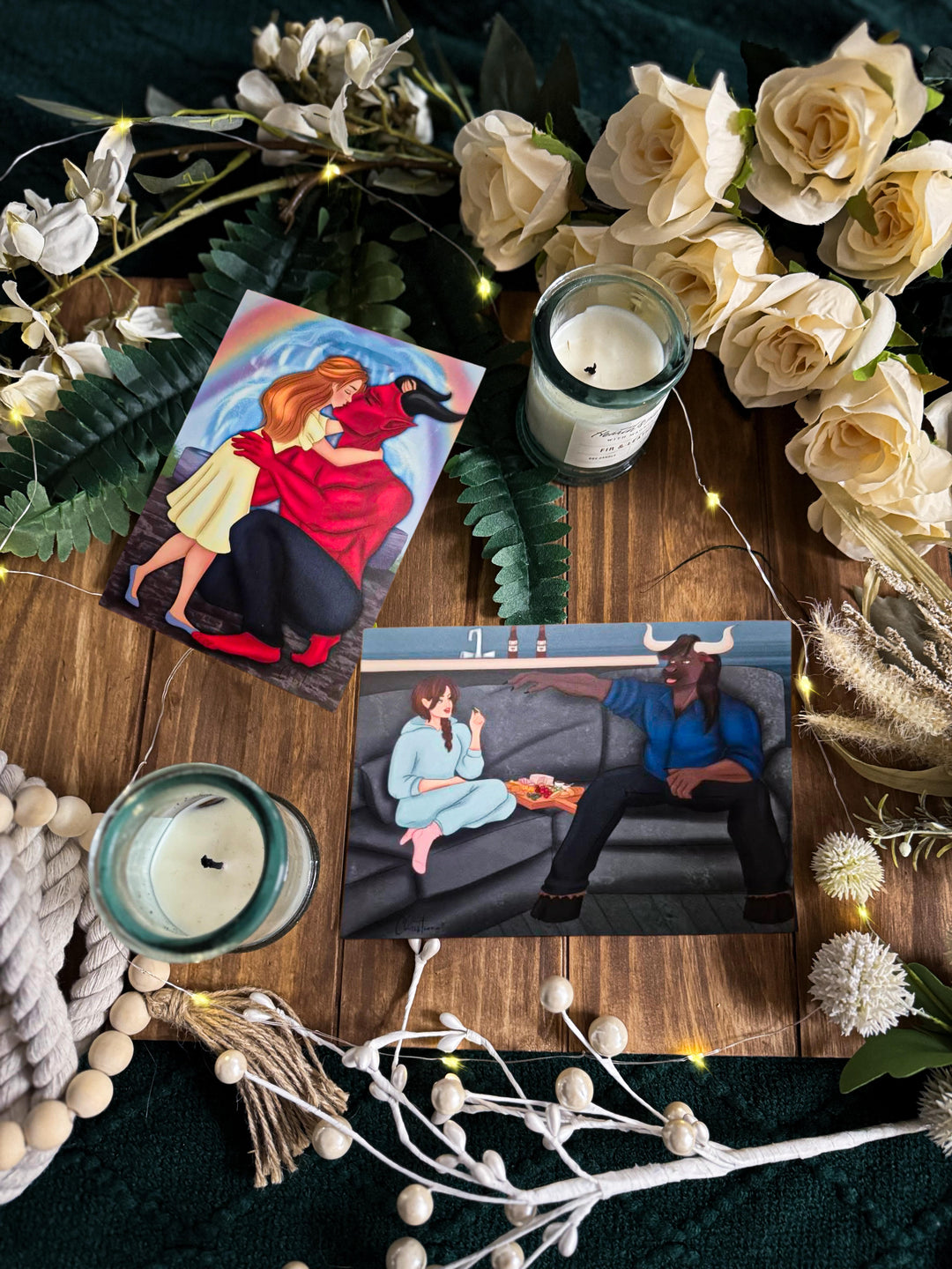 Two monster romance art prints—redhead kissing a horned demon and dark-haired woman lounging with a cozy minotaur.